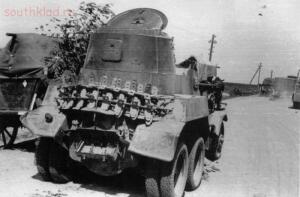 Немецкое тыловое подразделение следует мимо брошенного на дороге советского БА-10