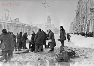 Жители блокадного Ленинграда набирают воду, появившуюся после артобстрела в пробоинах в асфальте, декабрь 1941 года / Фото: Wikimedia Commons / РИА Новости / Борис Кудояров